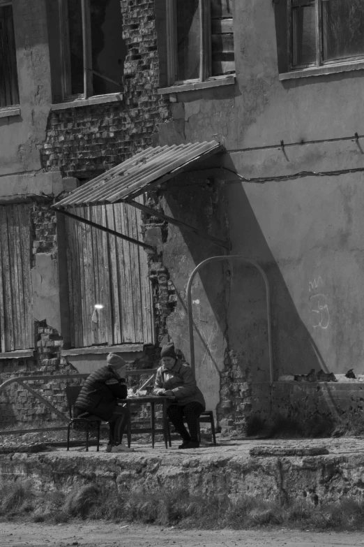 an old pograph of people at table outside