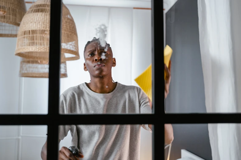 a man with no hair in front of a window