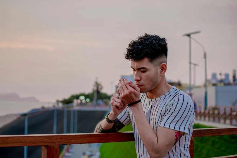 a man with his hands clasped in prayer by the beach