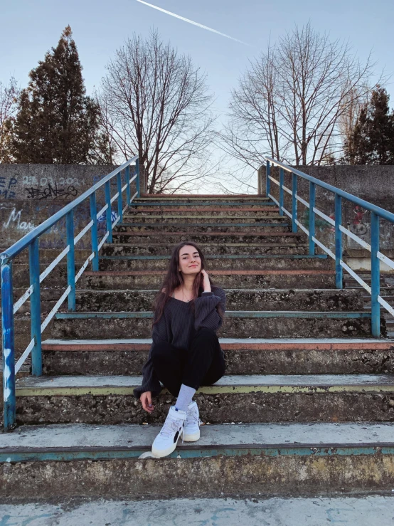 a young woman sitting on the stairs of a building