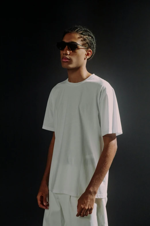 young man in a white tee shirt against black