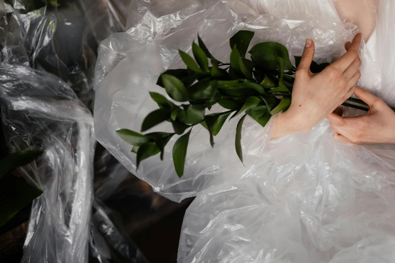 someone holding flowers that have been wrapped in plastic