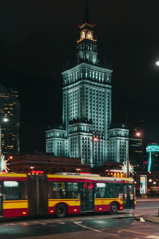 a city street with buses in front of tall buildings