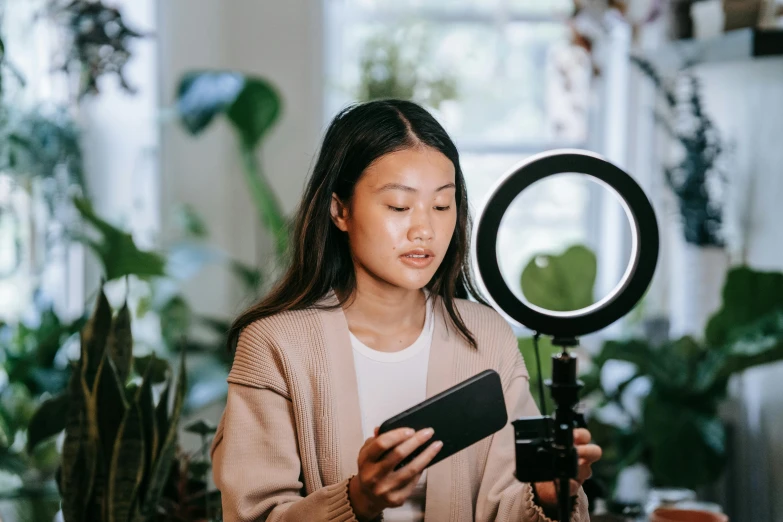 a woman holds up her phone and is filming in the background