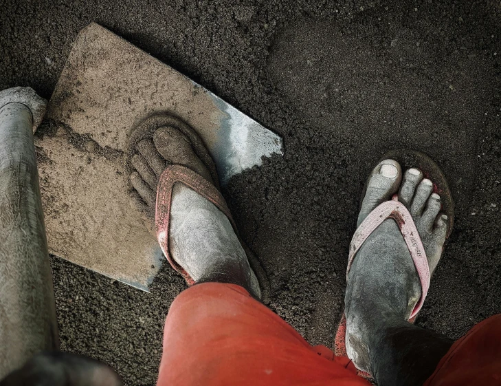 the feet of a person standing on a concrete floor