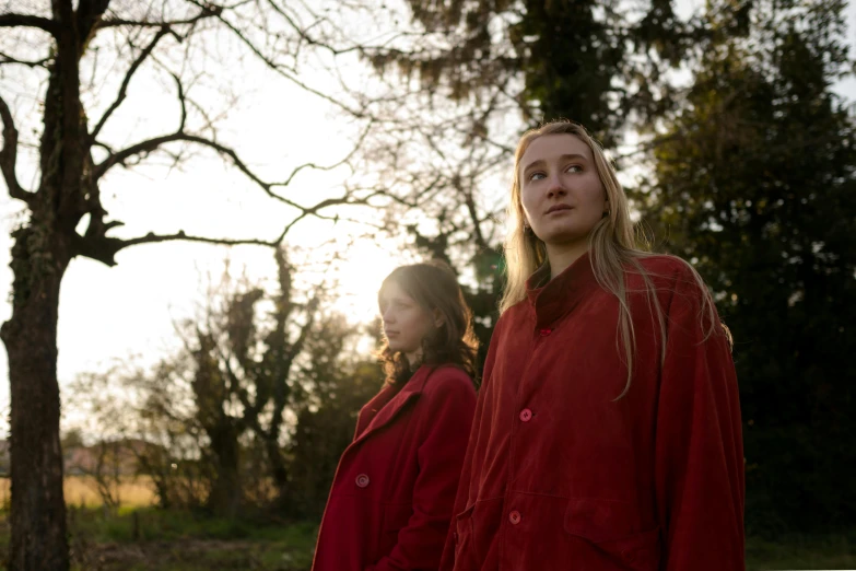 two girls in red jackets are standing side by side