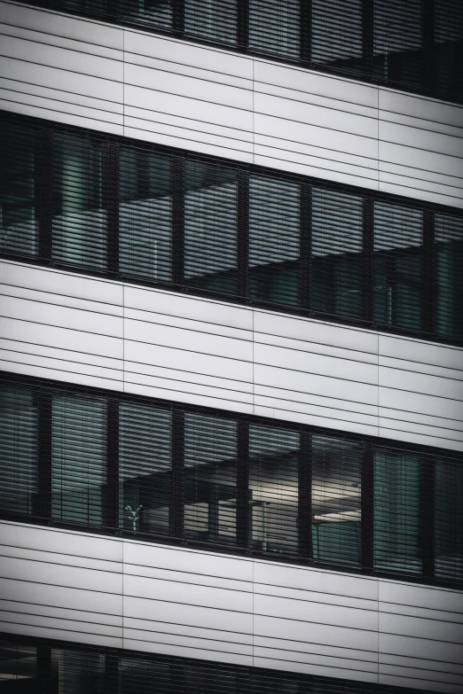 a tall white building with windows reflecting light