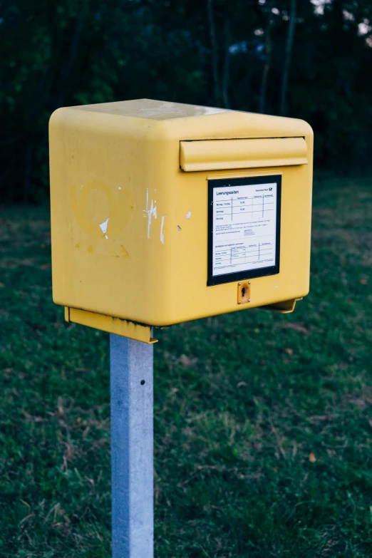 a yellow box sitting on top of a metal post