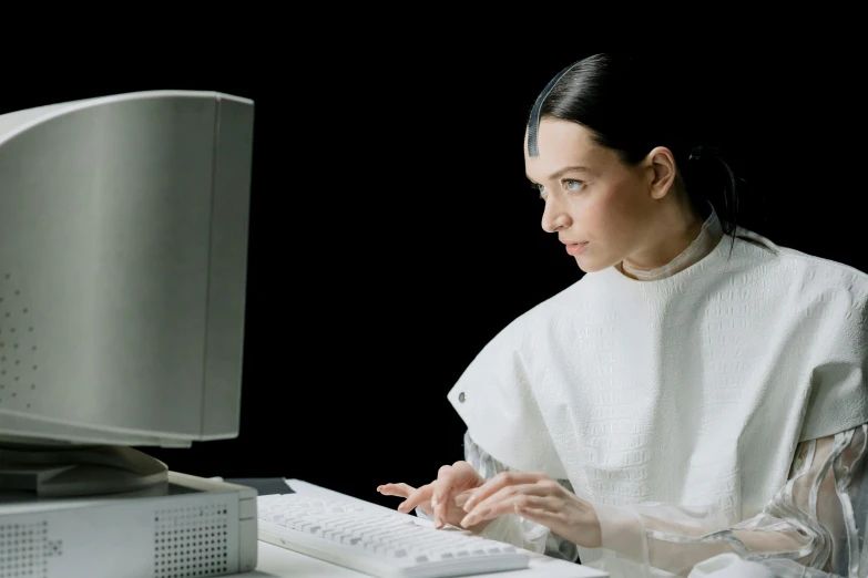 the woman is sitting in front of a computer