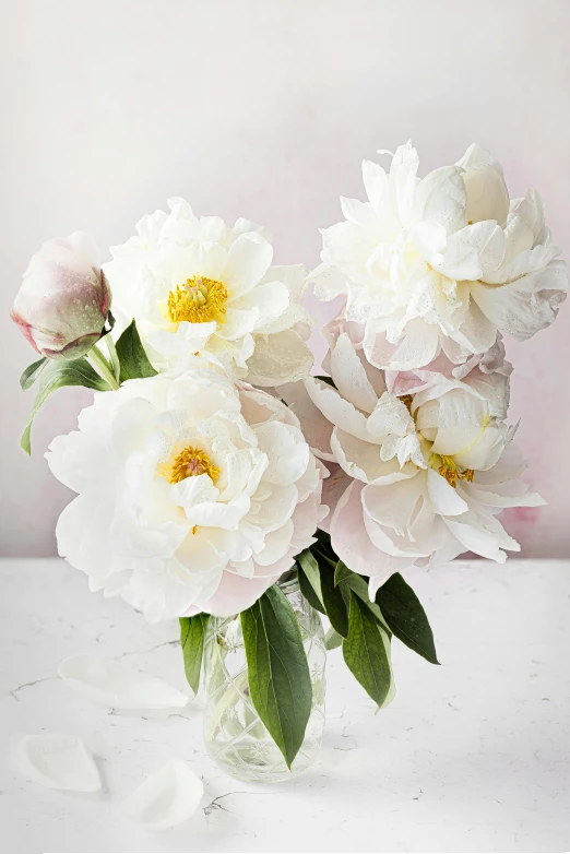 a glass vase filled with white and pink flowers