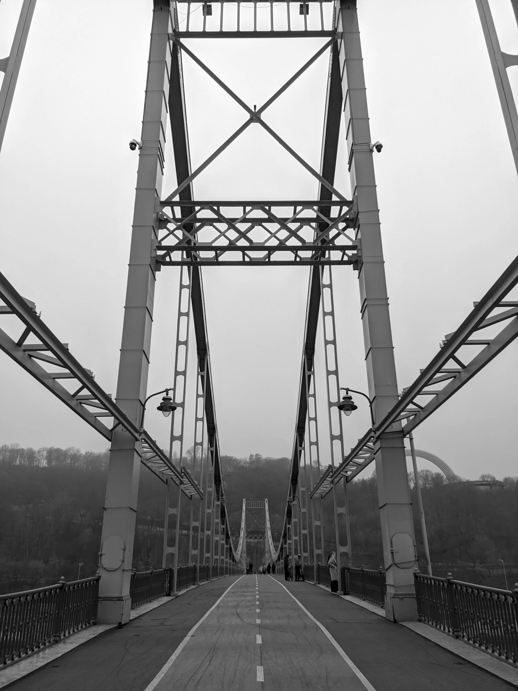 a bike is going down a bridge in black and white