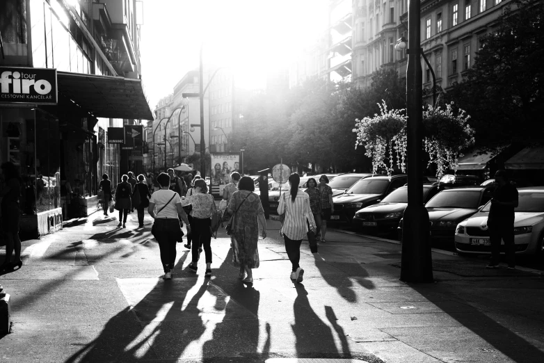 pedestrians walking down the sidewalk of a crowded street