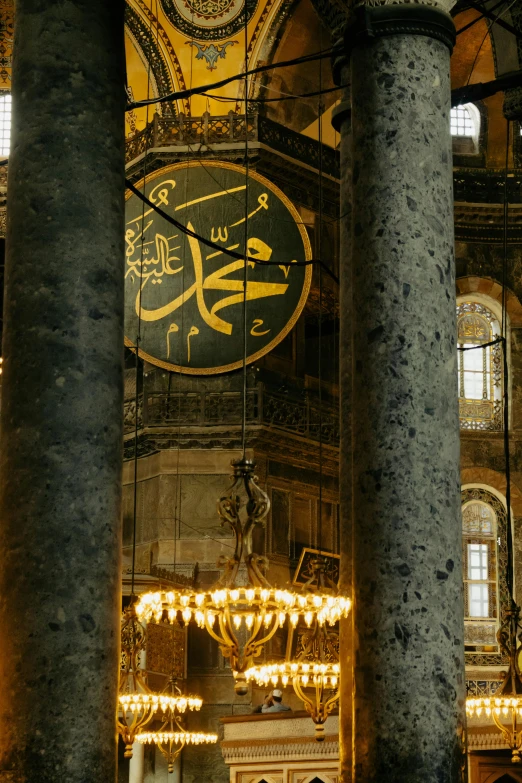 the interior of an elegant, ornate building with chandelier and clocks