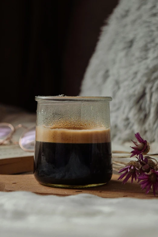 a cup on a table that is on top of the bed