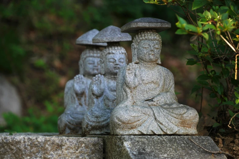 two statues sitting on top of some stone