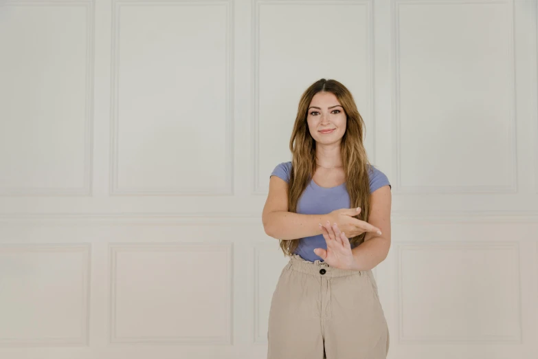 a woman wearing tan pants and a blue shirt