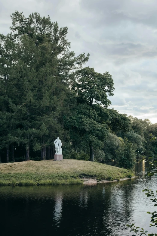 a statue sits on an island in the middle of a river