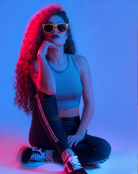 an image of a woman wearing glasses and sitting on the ground