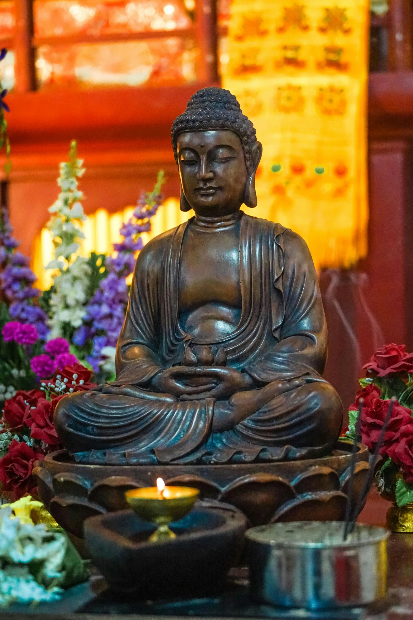 a buddha statue with a candle in front of it