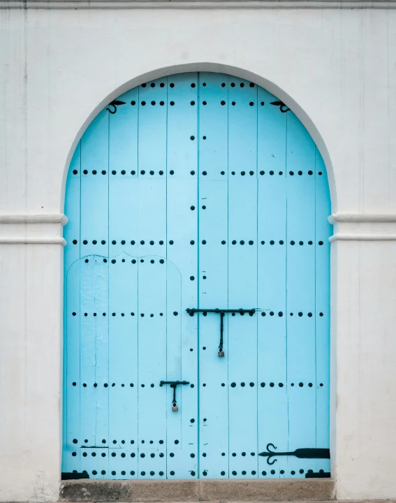 a large blue door sits in front of a white building