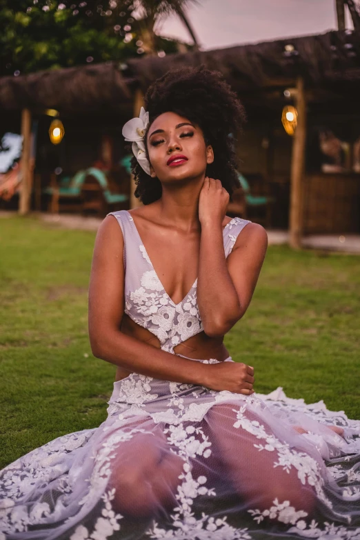 a woman sits on the ground in a gown