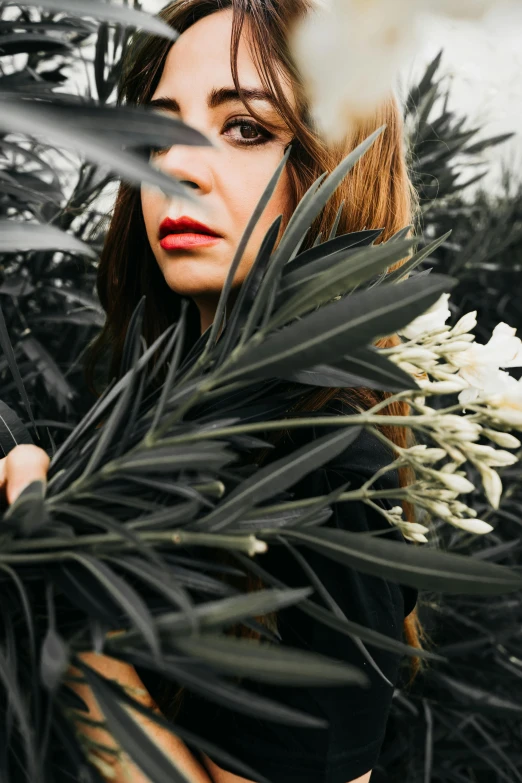 a woman posing in front of some trees