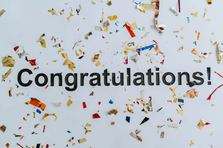 a piece of paper that reads congratulations surrounded by confetti