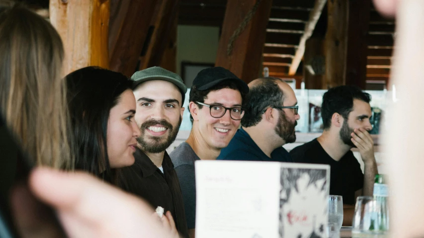 a group of people are standing at a restaurant table