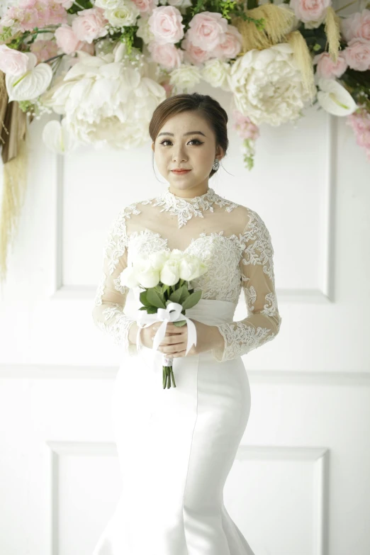 a bride wearing a long white gown holding flowers