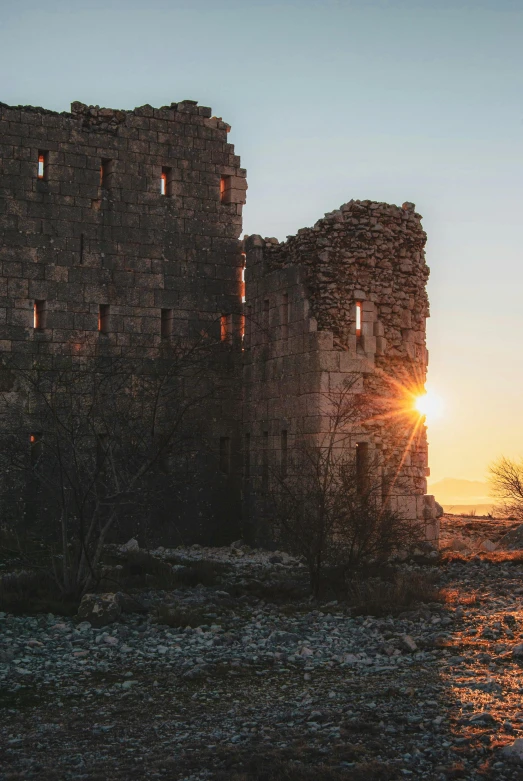 the sun is going down in a castle like setting