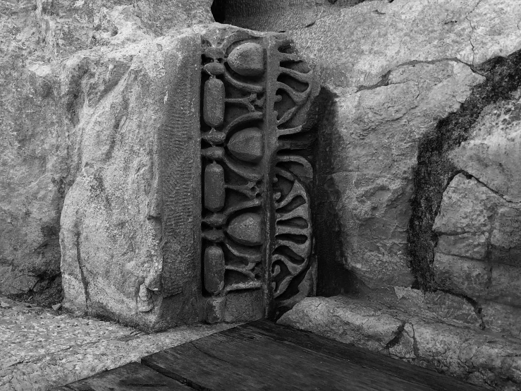 two stone sculptures near some rocks