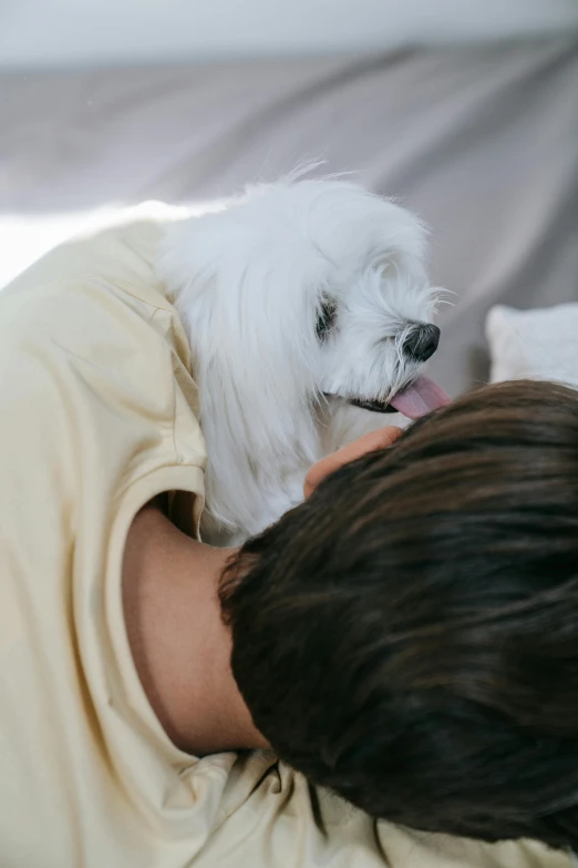 there is a man holding his dog in the bed