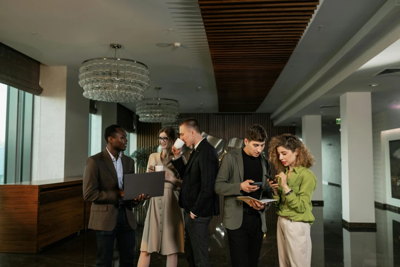 three people standing in an office lobby next to each other with their phones