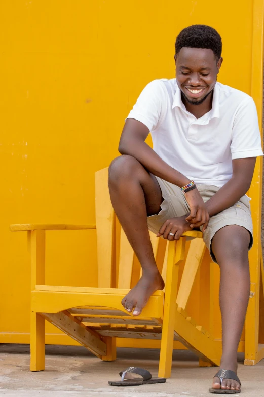 a man smiles while sitting on a bench