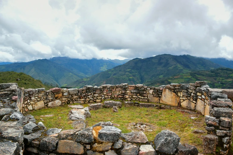 a large stone structure in the middle of some mountains