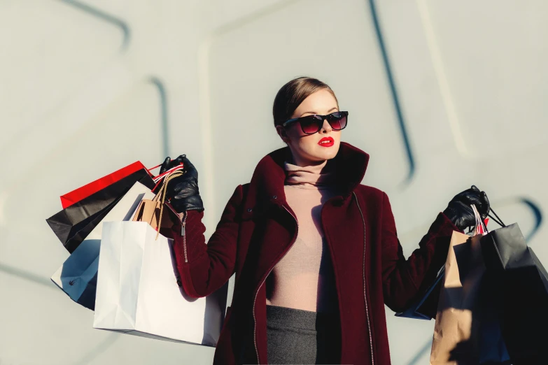 a woman holding up shopping bags with her eyes closed