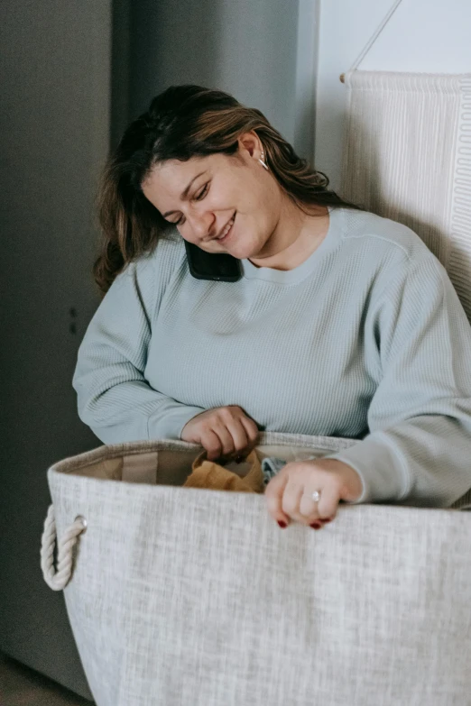 a woman sits inside an old laundry hammock