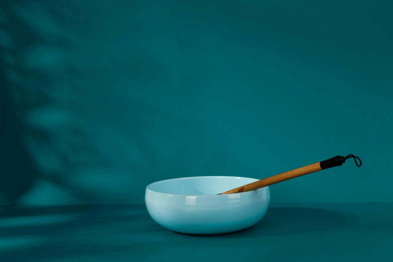 a white bowl with a brown handle holding an umbrella