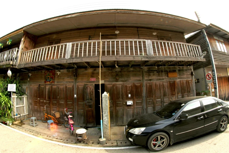 a black car is parked outside a two story building