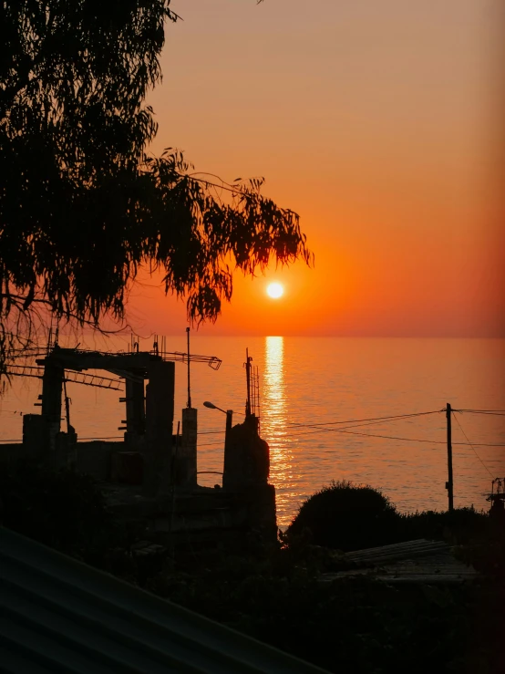 the sun sets over the water behind the buildings