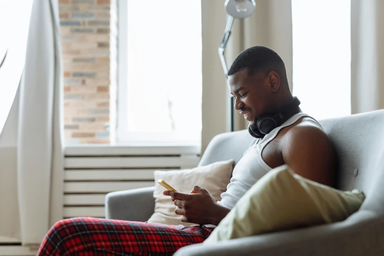 a man sits on a couch in the sunlight