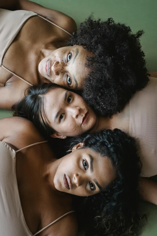 three young adults laying on top of each other