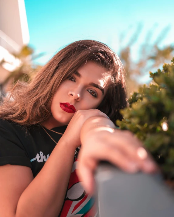 a woman leaning on the fence with a red lip