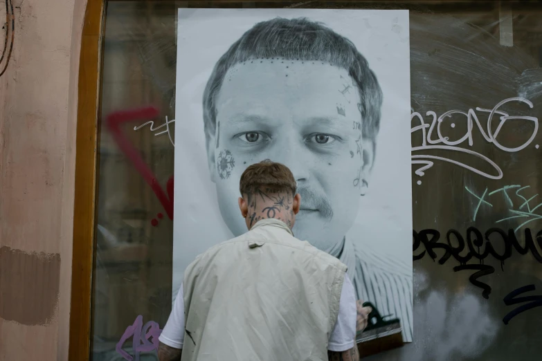 man with his nose shaved in front of a billboard