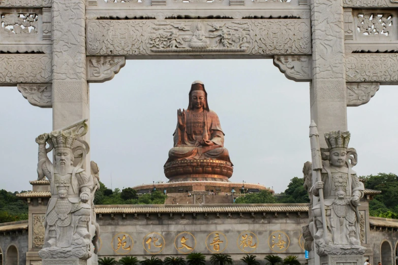 large buddha statue sitting between two other sculptures