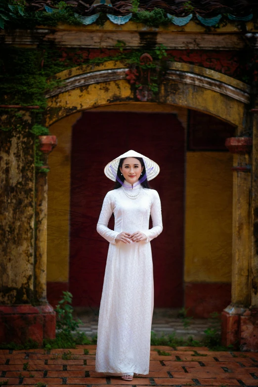 a girl is wearing a white dress and hat