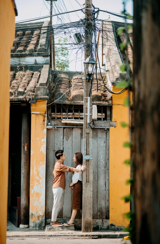 two people on street corner, one holding onto the door