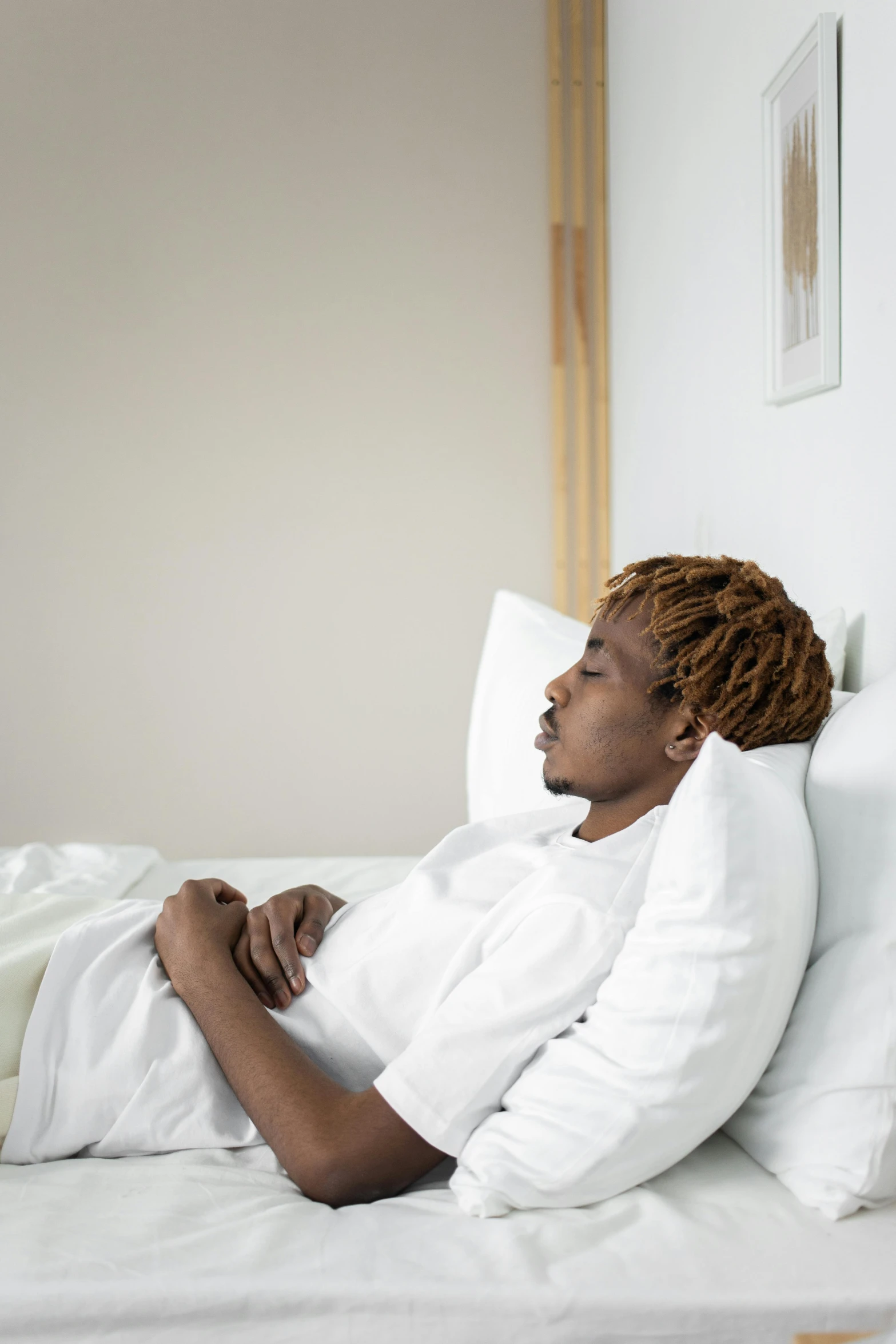 woman lying on bed with all white linens