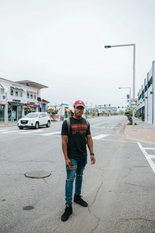 a man wearing a hat standing in the middle of the road