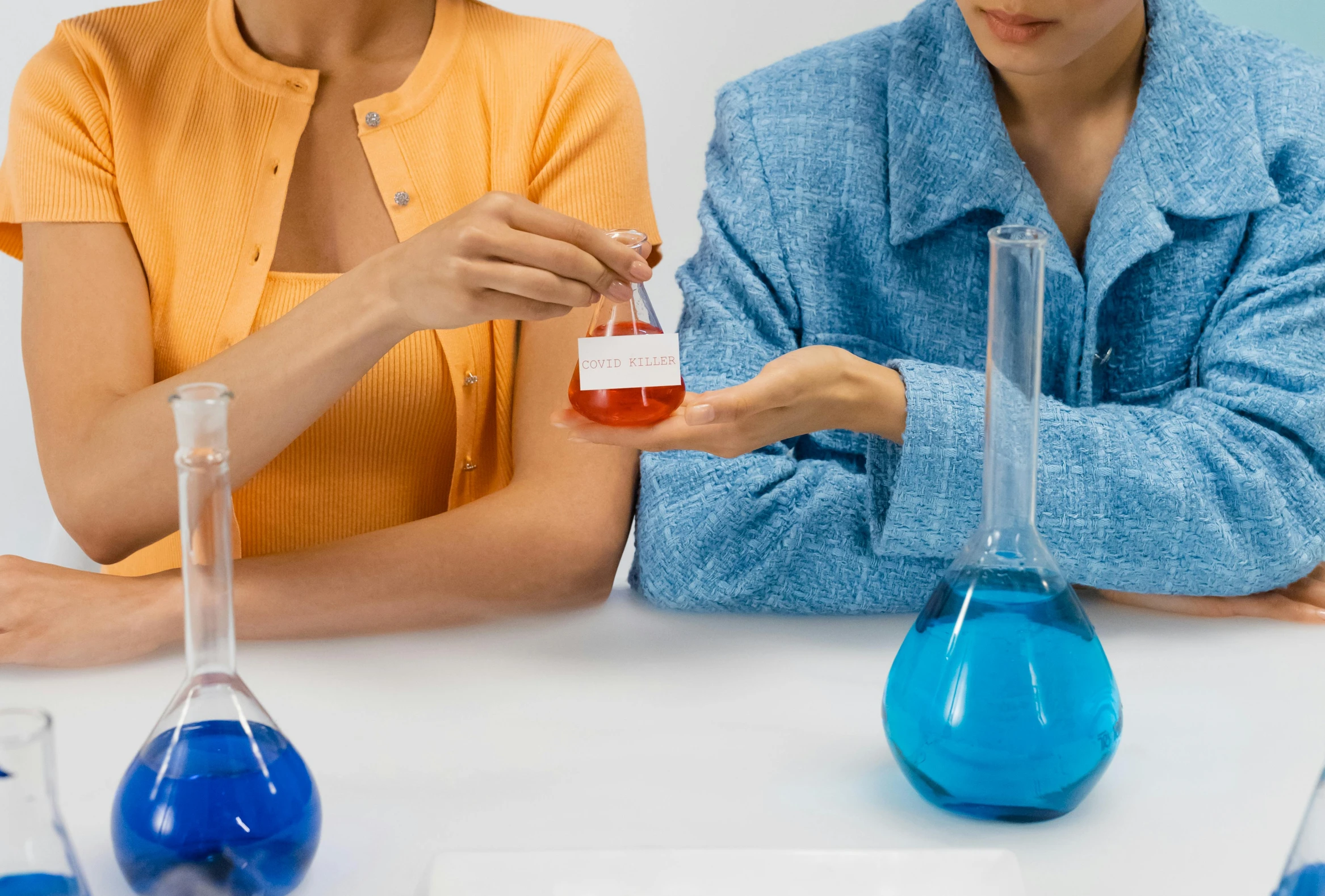 two people working with various colored liquid in test tubes